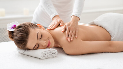 Obraz na płótnie Canvas Young caucasian woman enjoying healing body massage