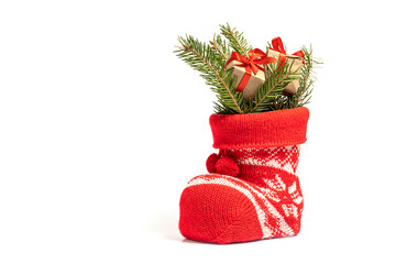 Little gifts with fir branches in Santa's boot