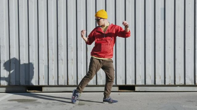 Dancing man funny break dance, happy rhythmically waving his arms against grey textured street wall. Playful crazy man dance emotions. Breakdancing, street dancing, hiphop, freestyle dance. Lifestyle 