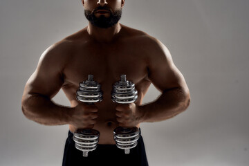 Blacked figure of young muscular bodybuilder with dumbbells