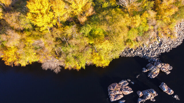 Overhead Aerial View of Dniper river in Zaporozhye , Ukraine. The deep dark water river and forest foliage in autumn
