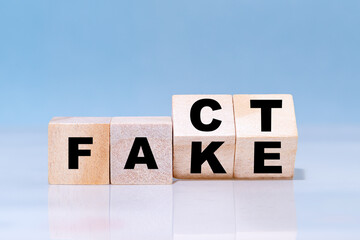Wooden cubes are turned over for change wording from fake to fact.