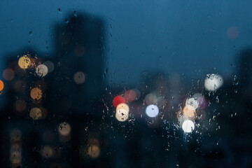 Abstract bokeh night  light in city background, night city through rain window, defocused background