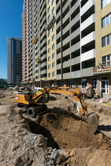The excavator digs a trench. Construction site. Production of apartments, social housing.