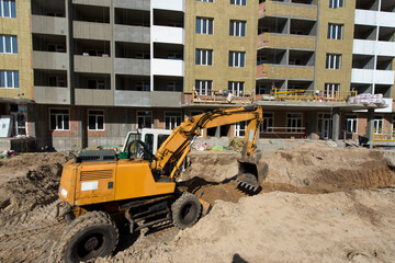 The excavator digs a trench. Construction site. Production of apartments, social housing.