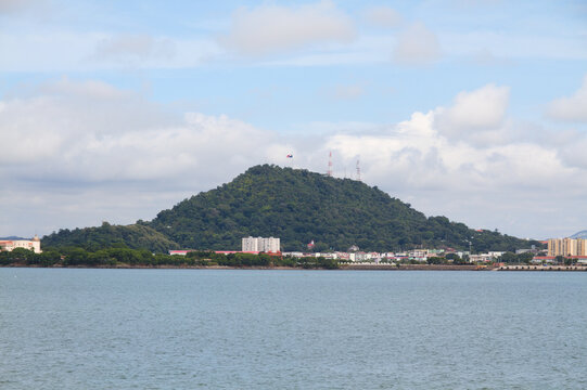 Cerro Ancon mountain next to the ocean in Panama City with flag on top.