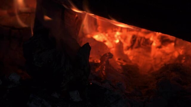 Flames of burning logs in fire in dark