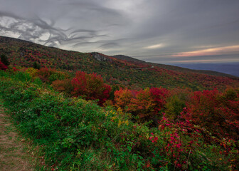 Fototapeta na wymiar Unusual cloud formations build above the mountaintop of the Blue Ridge Parkway of North Carolina during peak fall colors