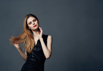 Fototapeta premium Beautiful woman in black dress red hair gray background Copy Space Model