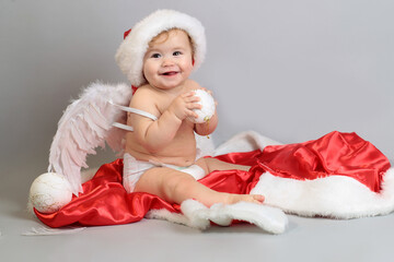 Baby first Christmas. Little child celebrates new Year holidays. Baby with santa hat with gift. Santa baby.