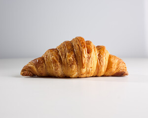 Fresh crispy croissant on a white isolated background