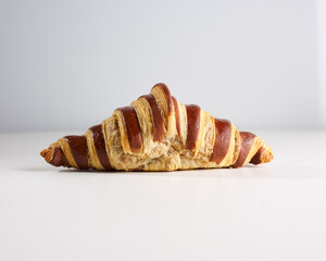 Fresh gentle croissant decorated with chocolate with chocolate creamy filling isolated on white background