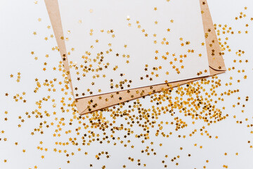 Blank note with envelope and gold glitter stars on white background