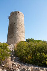 Fototapeta na wymiar Medieval castle watchtower ruin. Torre Abadum or Badum tower. Beautiful protected Serra d'Irta Natural Park, Peniscola, Castellon province, Spain. Vertical shot.