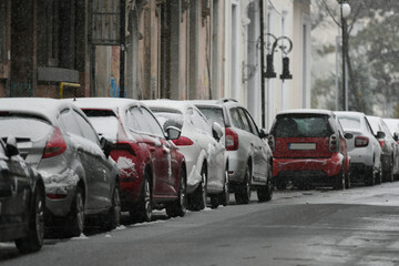 Cars covered in snow after a cold day.