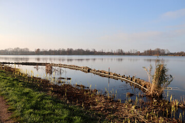 Water with reed strips and wooden piers on the Rottemeren