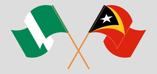 Crossed and waving flags of Nigeria and East Timor