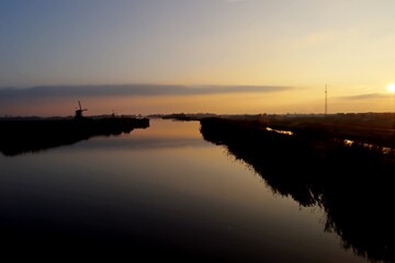 Sunset over the river Rotte in Zevenhuizen with windmills of the Molenviergang