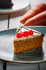 A slice of carrot cake being cut with a spoon from the load on a plate
