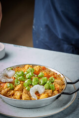 Cooking and making a traditional Spanish Paella. Traditional way of preparing Valencian paella