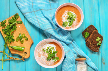 Red lentil tomato soup - delicious vegetarian food on blue wooden background. Healthy lunch