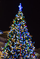 Blurred background with Christmas tree and winter decorations, at night.