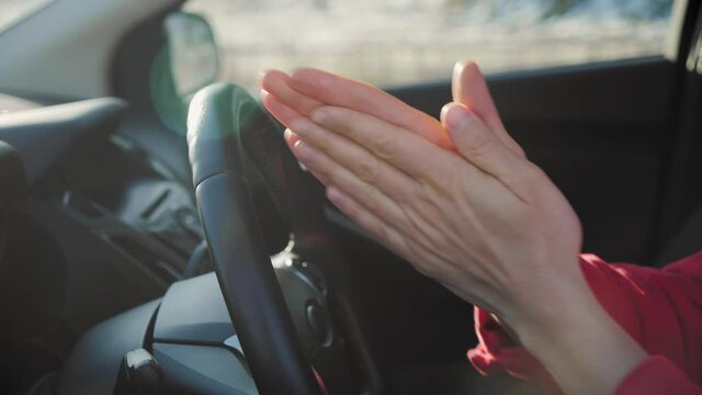 Asian man in car Desinfecting his Hands to protect from Coronavirus. Close up of man Wearing protection masks Sanitzing stearing wheel during the second wawe post COVID19. Car Wash or carsharing