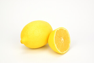 A whole lemon next to a half of another one isolated on white background.