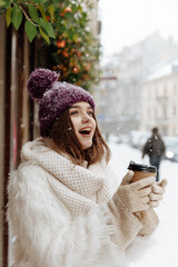 Cheerful woman posing on camera during snowfall