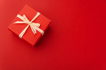 Fototapeta na wymiar Red gift box on red background