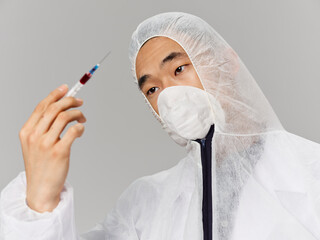 Male defender wearing medical clothes a syringe in the hands of a vaccine health close-up