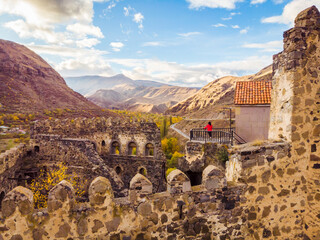 Female tourist stands on top of Khertvisi fortress and looks to stunning landscape panorama in Vardzia. Travel copyspace background.