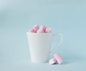 pink marshmallow in white cup on blue background. Christmas, mother's day, birthday card concept