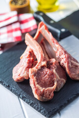 Slices raw lamb chops on stone cutting board