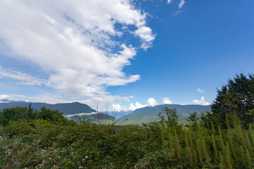 Beautiful mountain landscape against a blue sky with clouds, used as a background or texture