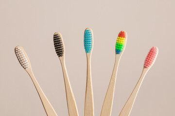 Multicolored bamboo toothbrushes on beige background