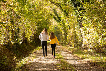 Deux jeunes filles marchant sur un petit chemin lumineux en automne