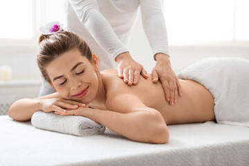 Obraz na płótnie Canvas Peaceful woman enjoying back massage at spa
