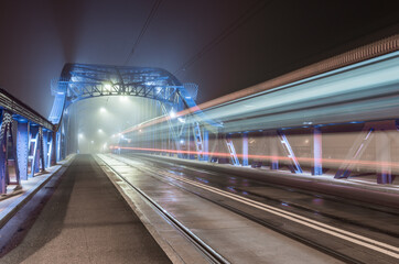Fototapeta na wymiar Krakow Poland, tram light trails on Pilsudski bridge over Vistula river in the night