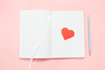 Open notebook with red heart on pages and pencil