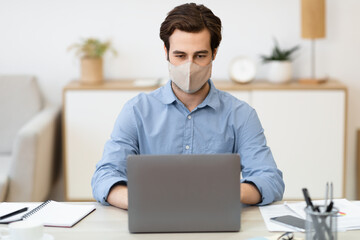 Businessman Wearing Face Mask Working On Laptop Sitting At Workplace