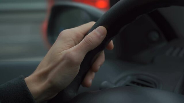 close-up shot of hands of man holding a wheel of a car