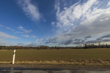 Beautiful nature landscape view on spring day. Plowed field merging with blue sky and white clouds....
