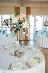 A beautiful vase of flowers on a table in a luxury restaurant. Wedding decorations