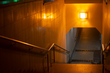 Underground passage under the road at night. Staircase down in the city. Pedestrian traffic...