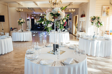 A beautiful vase of flowers on a table in a luxury restaurant. Wedding decorations