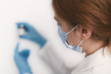 Female doctor holding in her hand coronavirus vaccine - covid-19 health concept