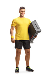 Full length portrait of a young man holding an aerobic stepper and smiling