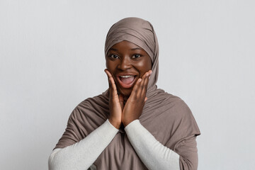 Surprised Black Woman In Hijab Touching Face In Excitement, Looking At Camera