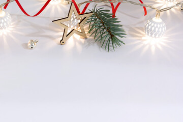 Christmas composition of fir branches, wooden stars, garlands of white luminous balls and red...